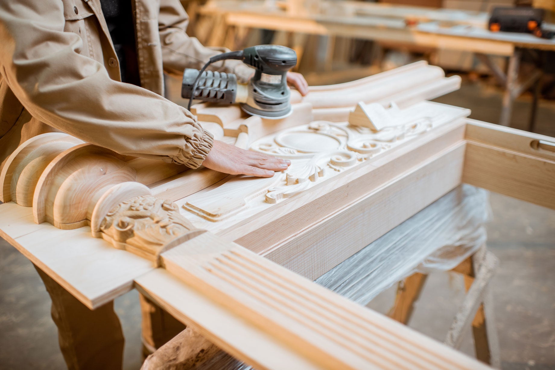 Carpenter inspecting CNC-carved wood detailing.