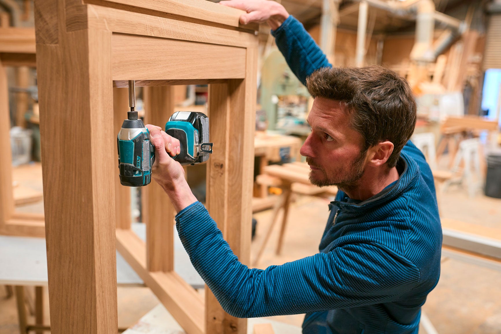 Carpenter operating a CNC router for woodworking applications.